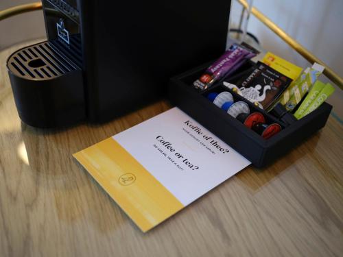 a box of pens and a card on a table at voco The Hague by IHG in The Hague