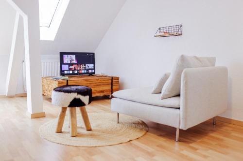 a living room with a chair and a tv at Große City-Wohnung, salt apartments Weissenfels in Weißenfels