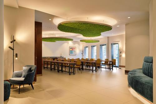 a dining room with a long table and chairs at voco The Hague by IHG in The Hague