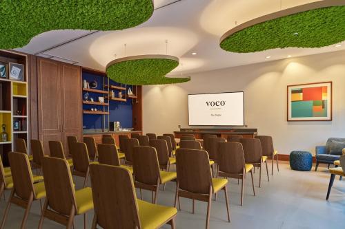 a room with rows of chairs and a whiteboard at voco The Hague by IHG in The Hague