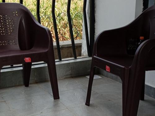 two chairs sitting in front of a window at Afri Homes in Kisumu