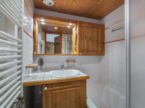 a bathroom with a sink and a tub and a mirror at Appartement cosy à Méribel avec piscine, spa et proche pistes - FR-1-566-7 in Les Allues