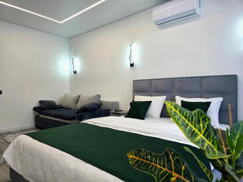 a bedroom with a large bed and a couch at Belvedere Apart 2, parking in Ivano-Frankivsʼk