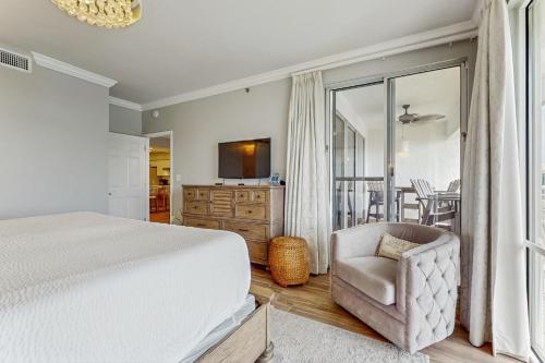 sypialnia z łóżkiem, krzesłem i telewizorem w obiekcie High Pointe 433 w mieście Seacrest