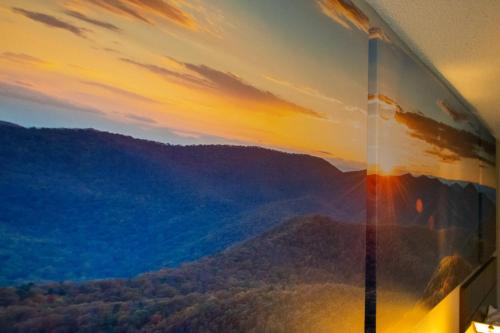 a painting of a mountain view on a wall at Days Inn by Wyndham Caddo Valley Arkadelphia in Caddo Valley
