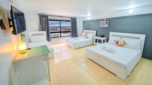 a living room with two beds and a flat screen tv at Casa Cecilia in El Nido