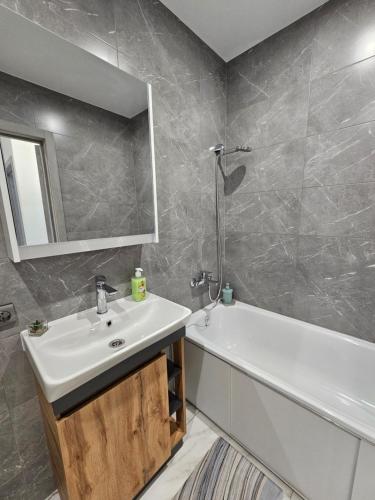 a bathroom with a sink and a bath tub and a mirror at Новинка ЖК Тріумф поряд вокзалу in Luts'k