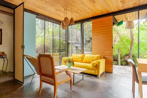 a living room with a yellow couch and a table at Cabañas de la Insolente in Tepoztlán