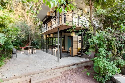 a house with a balcony and a patio at Cabañas de la Insolente in Tepoztlán
