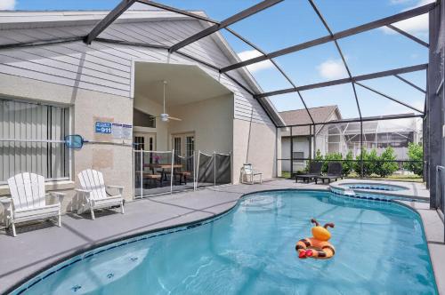 a pool with a toy in the water in a house at Luxury 4-Bedroom Home with Private Pool, Jacuzzi, AC, Wi-Fi, Cable TV, 5 Minutes from Disney in Kissimmee