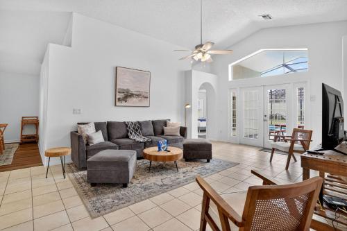 a living room with a couch and a table at Luxury 4-Bedroom Home with Private Pool, Jacuzzi, AC, Wi-Fi, Cable TV, 5 Minutes from Disney in Kissimmee
