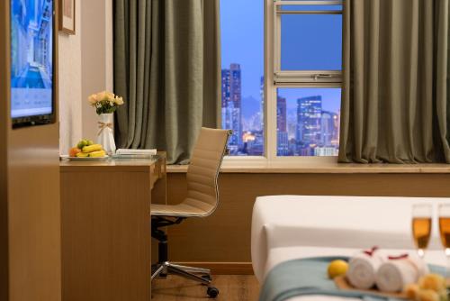 a hotel room with a desk and a bed and a table with a chair at True Go Hotel - Guangzhou International Conference Center Memorial Hall Subway Station in Guangzhou