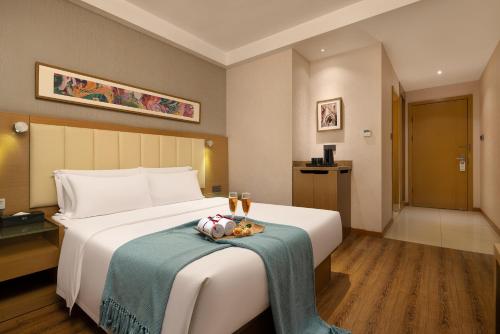 a hotel room with a bed with a tray of food on it at True Go Hotel - Guangzhou International Conference Center Memorial Hall Subway Station in Guangzhou