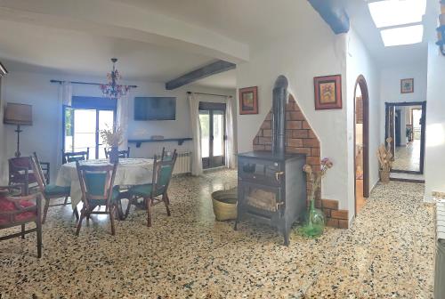 a living room with a fireplace and a table with chairs at Apartamento Ferreirola- Casa rural La Chaparra in Pitres