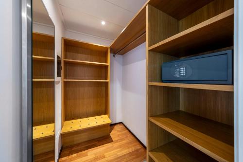 a walk in closet with wooden shelves and a tv at Eurostars Monte Tauro in Taormina