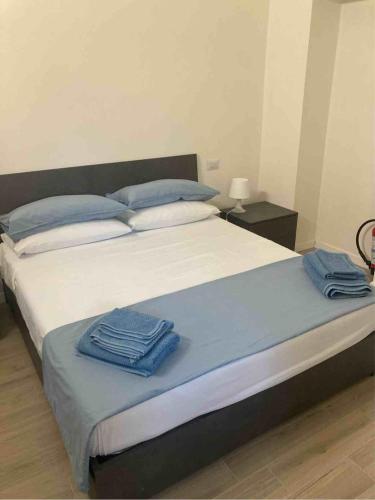 ein Bett mit zwei blauen Handtüchern darauf in der Unterkunft Casa Coralli in Pavia