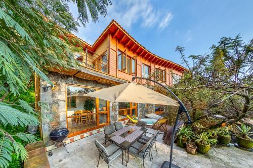 a house with a table and an umbrella at Casa Aluna - Oasis in Mountain - Premium 3 bedroom Villa in Tepoztlán with WiFi in Tepoztlán