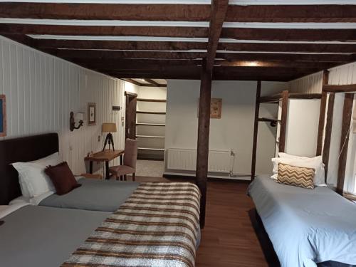 a bedroom with two beds and a desk in a room at The Patagonian Lodge in Coihaique