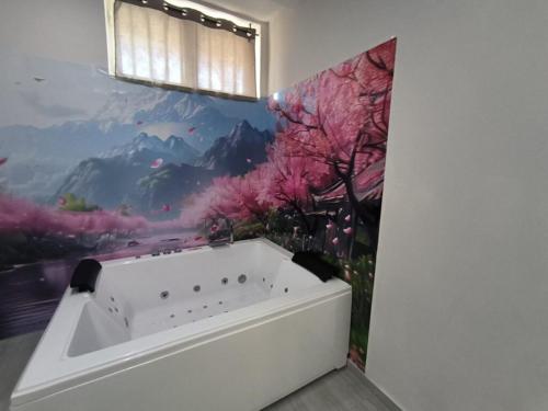 La salle de bains est pourvue d'une baignoire et d'une peinture murale. dans l'établissement B&B Viva Street, à Nola
