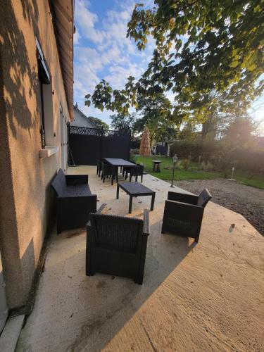 a group of tables and benches next to a building at Le gite d 'Amélie maison rénovée 6 couchages 2 salles de bains in Célon