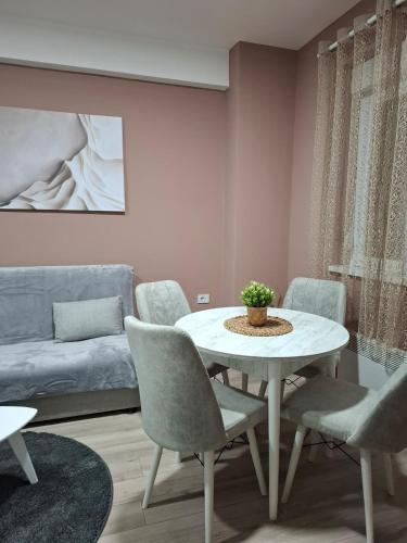 ein Wohnzimmer mit Tisch und Stühlen und einer Couch in der Unterkunft Apartman Dora in Jagodina