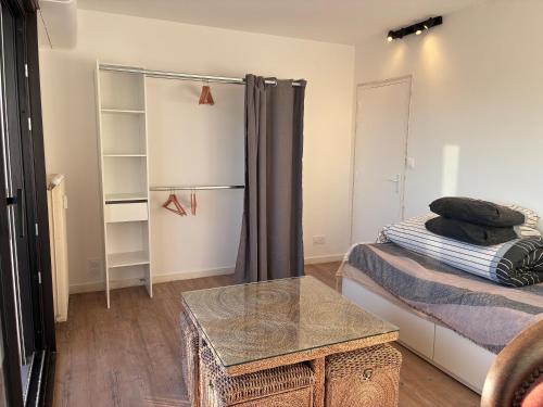 a room with a bed and a table in it at chambre avec salle de bain, cuisine, balcon, clim et parking privé ,bordeaux centre Nansouty in Bordeaux