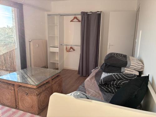 a living room with a glass table and a chair at chambre avec salle de bain, cuisine, balcon, clim et parking privé ,bordeaux centre Nansouty in Bordeaux