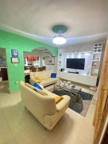 a living room with couches and a flat screen tv at Alojamiento en Bani, cerca de la playa y las Dunas in Colorado