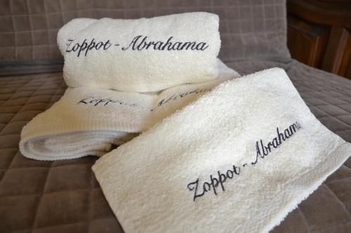 ソポトにあるZoppot-Abrahamaのベッドに書き込みのタオル2枚