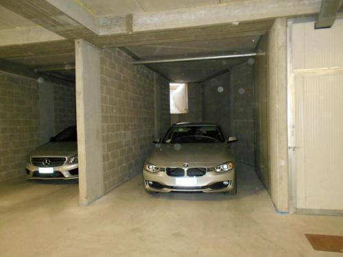 two cars are parked in a garage at La trifula bianca apts. in Alba
