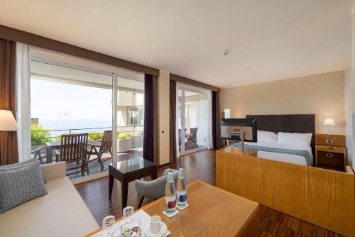 a hotel room with a bed and a view of the ocean at Eurostars Monte Tauro in Taormina