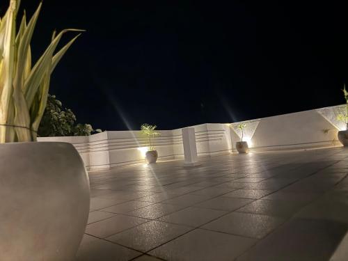a patio with a white fence and plants at night at Le Park Luxury Resort - TIE Hotels & Resorts in Puducherry