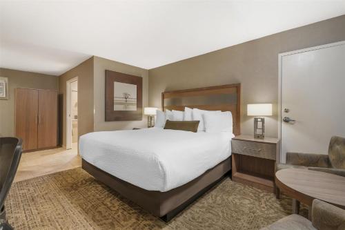 a bedroom with a large bed and a desk and a chair at Best Western Plus Anaheim Inn in Anaheim