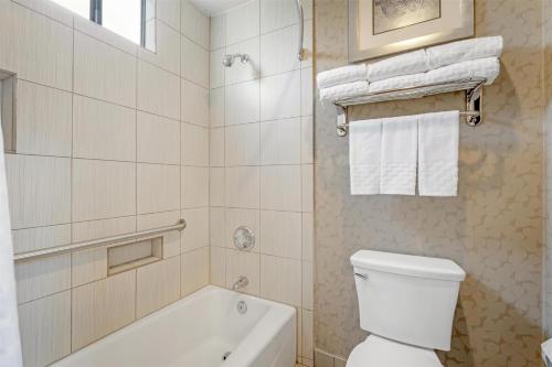 a bathroom with a white tub and a toilet and a sink at Best Western Plus Anaheim Inn in Anaheim