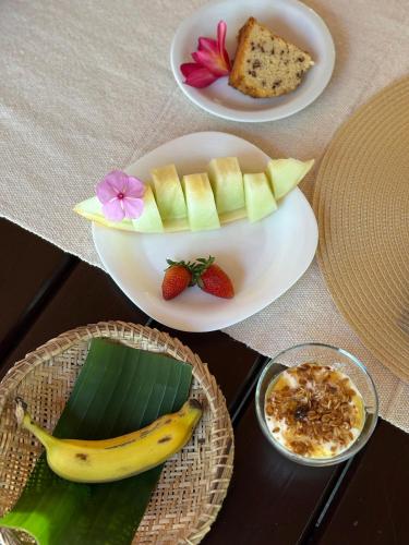 two plates of food with fruit on a table at Pousada Arraial dos Sonhos in Arraial d'Ajuda