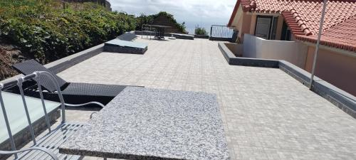 a patio with a table and benches on a building at Beautiful View 1 - Arco da Calheta - Ilha da Madeira in Arco da Calheta