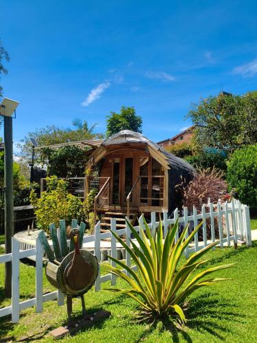 a house with a turkey in front of a fence at Glamping Cabañas Sharmont in Guarne
