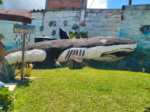 a large statue of a shark in the grass at Glamping Cabañas Sharmont in Guarne