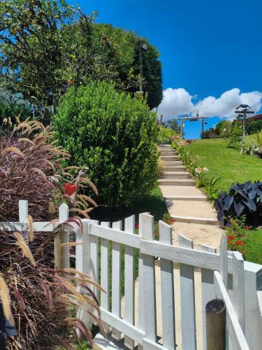 a white picket fence next to a sidewalk at Glamping Cabañas Sharmont in Guarne