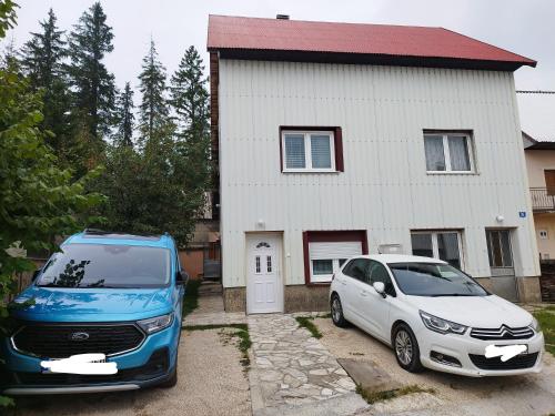 two cars parked in front of a house at durmitor_nature in Žabljak