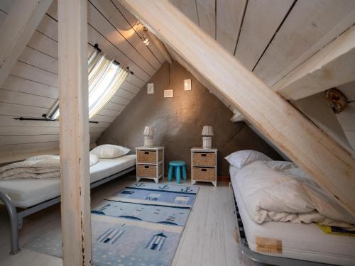 Un dormitorio abuhardillado con dos camas y una ventana. en Tuzzetje, en Nieuwpoort