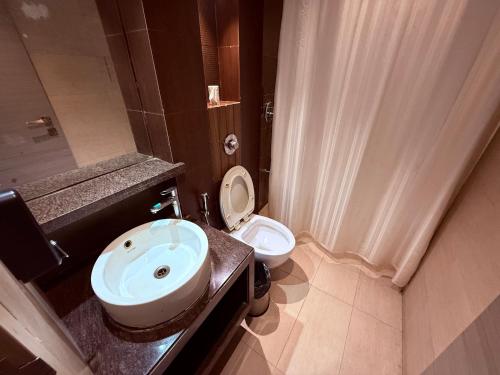 a bathroom with a sink and a toilet at HOTEL VARISHTTA - Koparkhairane - Navi Mumbai in Navi Mumbai