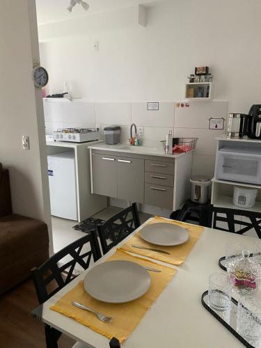 a kitchen with a table with plates on it at Ap com piscina e garagem prox do lago e shopping in Toledo