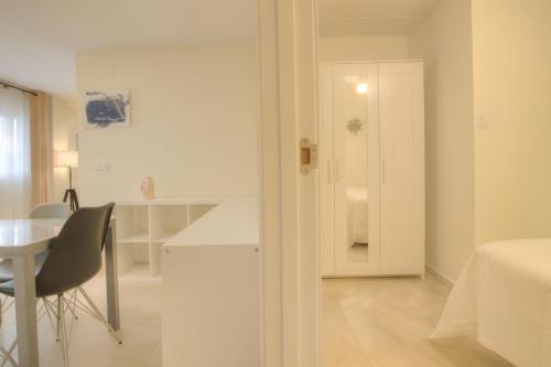 a white room with a desk and a table and a chair at Triana Home centro ciudad in Murcia