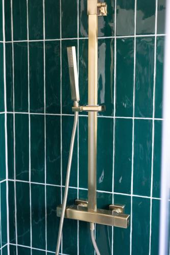 a toothbrush holder in a bathroom with blue tiles at THE LOFT Alnmouth in Alnmouth