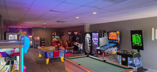 a room with several arcade games and a pool table at Tamarack Wisconsin Dells, a Ramada by Wyndham in Wisconsin Dells