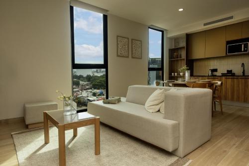 a living room with a couch and a table at Comfortable Apartment Near Expo Guadalajara Parking & WiFi in Guadalajara