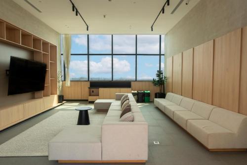 a living room with couches and a flat screen tv at Comfortable Apartment Near Expo Guadalajara Parking & WiFi in Guadalajara