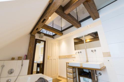an attic bathroom with a sink and a mirror at Ferienwohnung im Bortenmacherhaus in Neuburg an der Donau
