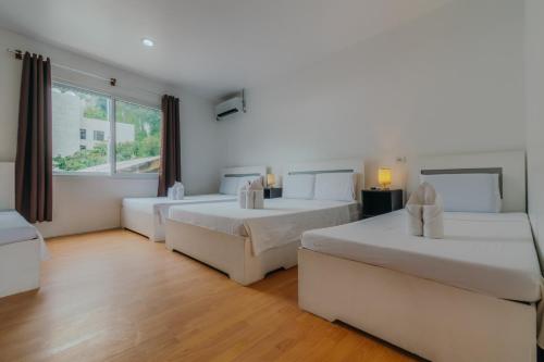 a bedroom with two beds and a large window at Casa Cecilia in El Nido